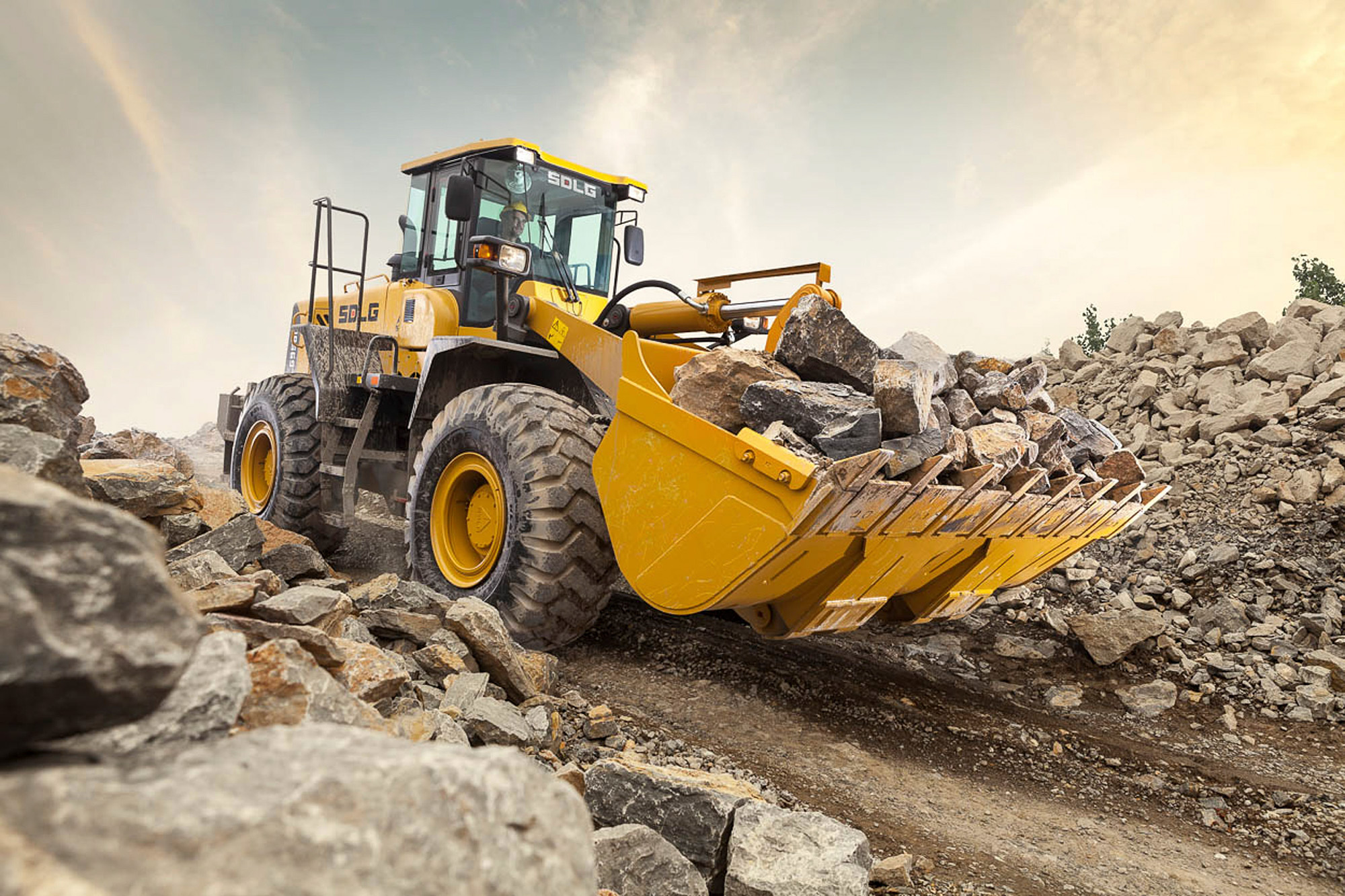Construction equipment photography services An SDLG wheel loader, laden with material, descends a hill in this construction equipment photography capture.