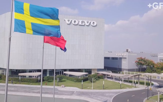 Aerial drone shot of the front of the Shanghai Volvo HQ with the Sweedish flag and Volvo logo. Professional corporate industrial video produced for GeorgFischer casting solutions that produces parts for Volvo automotive in China.