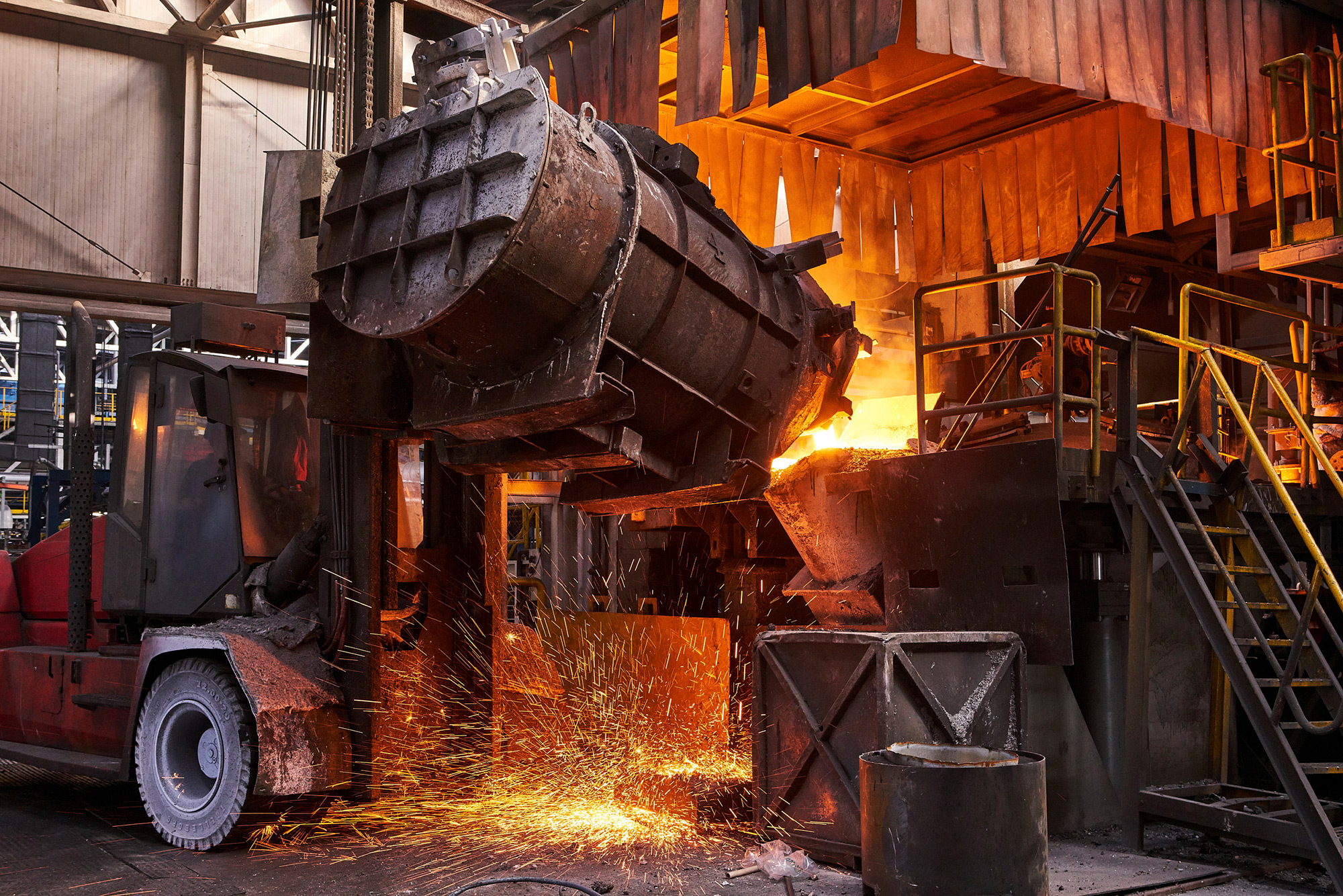 Industrial Mechanical Photography Services. GF+ foundry scene showing a large forklift pouring molten material into molds, captured for an industrial mechanical photography campaign.