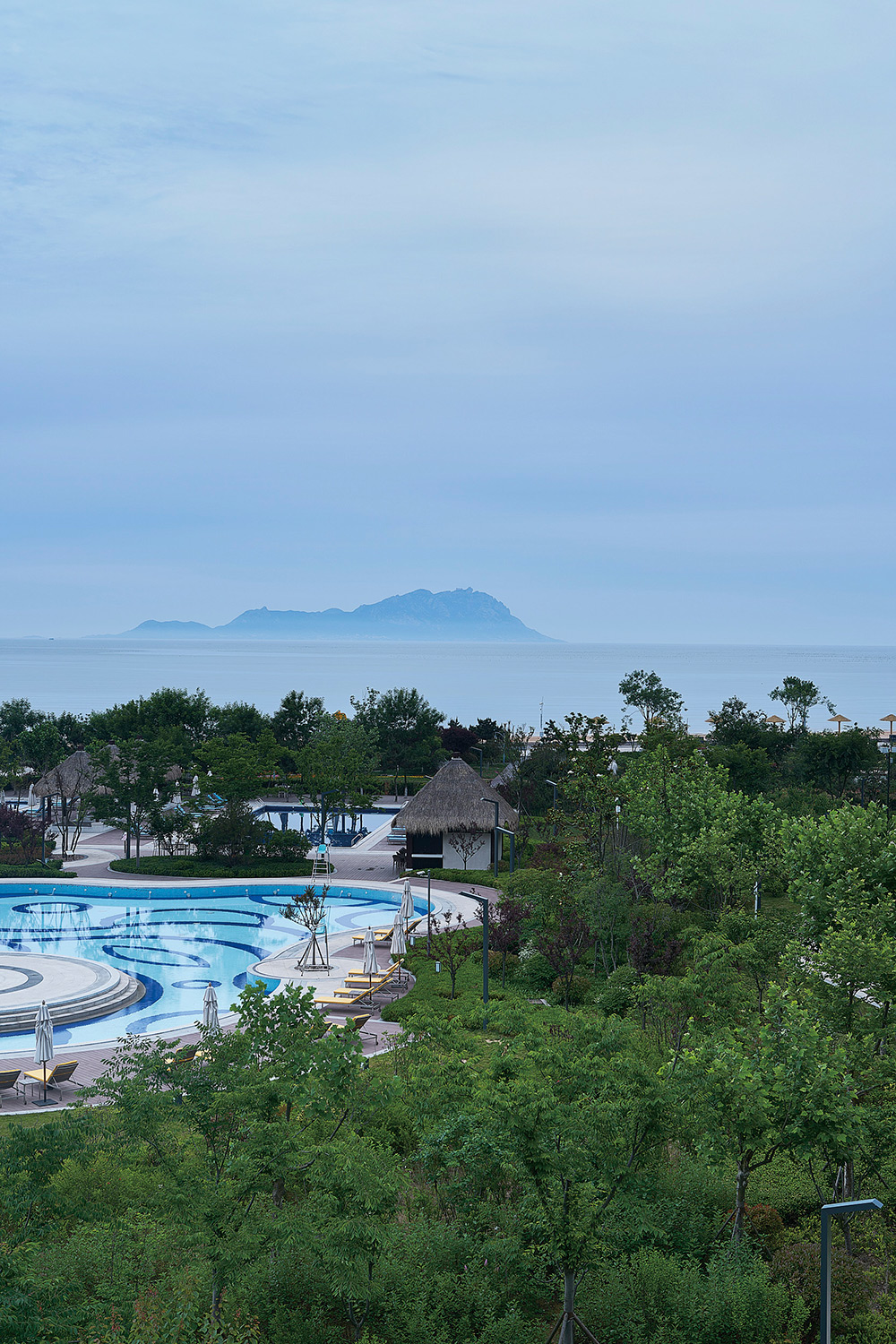 Hospitality architecture photography services Breathtaking view encompassing the beaches, island, and pool of the Hyatt Resort in Hainan, skillfully captured as part of hospitality architecture photography services.