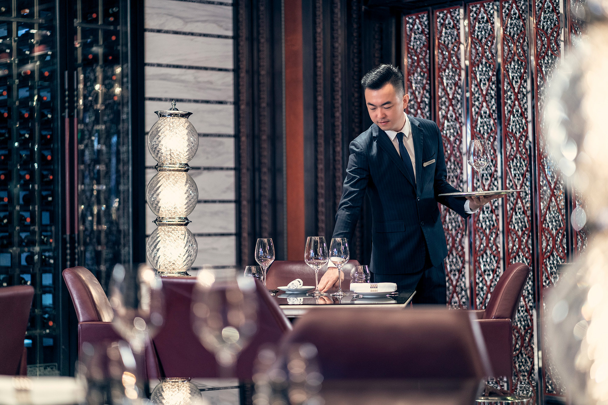 Hotel and Hospitality Staff Photography services Service staff diligently prepares the restaurant to welcome guests at the Four Seasons in Beijing, captured as part of a hotel and hospitality staff photography campaign.