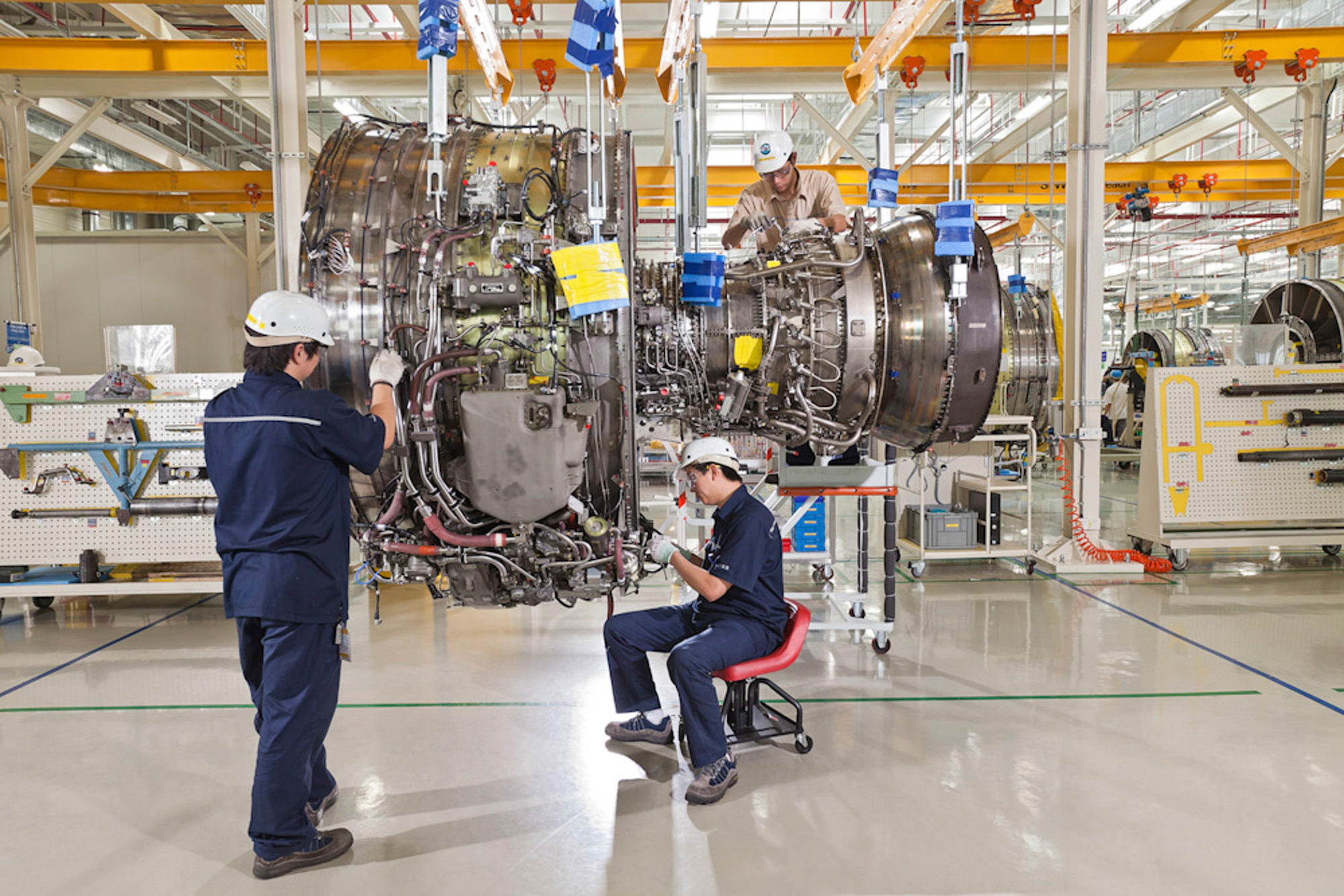 Industrial Mechanical Photography Two mechanics diligently working on a China Eastern jet engine inside the Pratt & Whitney hangar, captured for an industrial mechanical photography campaign.