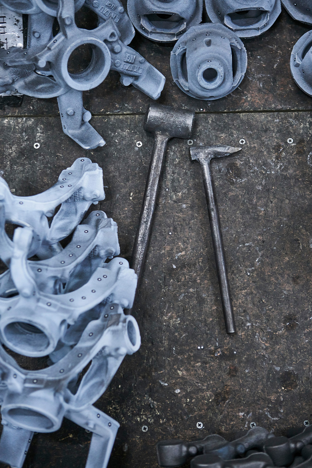 Industrial Mechanical Photography Tools for casting work neatly arranged on metal plates, captured for an industrial mechanical photography campaign.