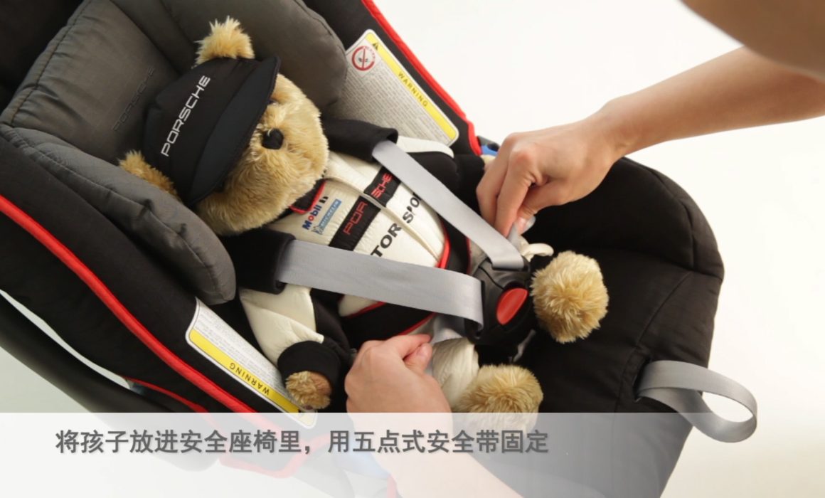 A model secures a teddy bear into a child seat. Professional instructional video series created for Porsche's child seats.