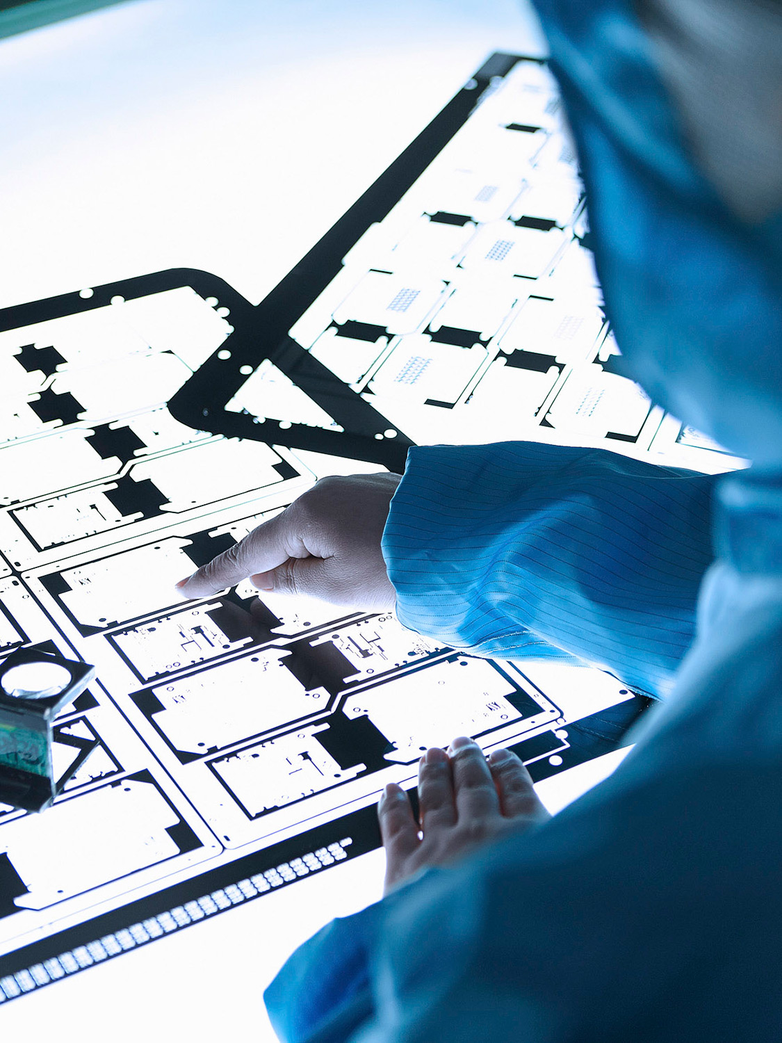 Science & Technology Photography services Lab technicians examining Flextronics negatives on a light table as part of our science and technology photography services.