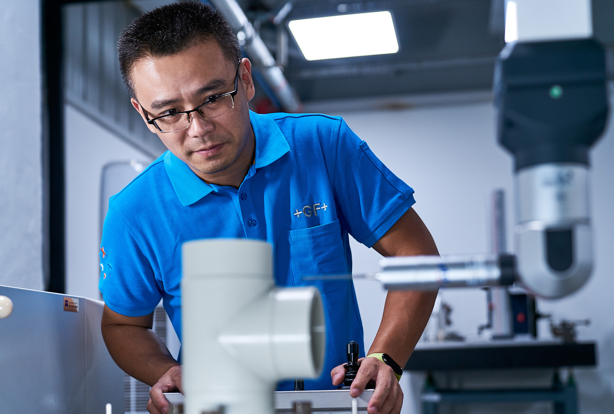 PhilippeRoy_Industrial_1701 Industrial photography showcasing a GeorgFischer employee conducting vital work within the factory lab, emphasizing technical expertise and quality control.