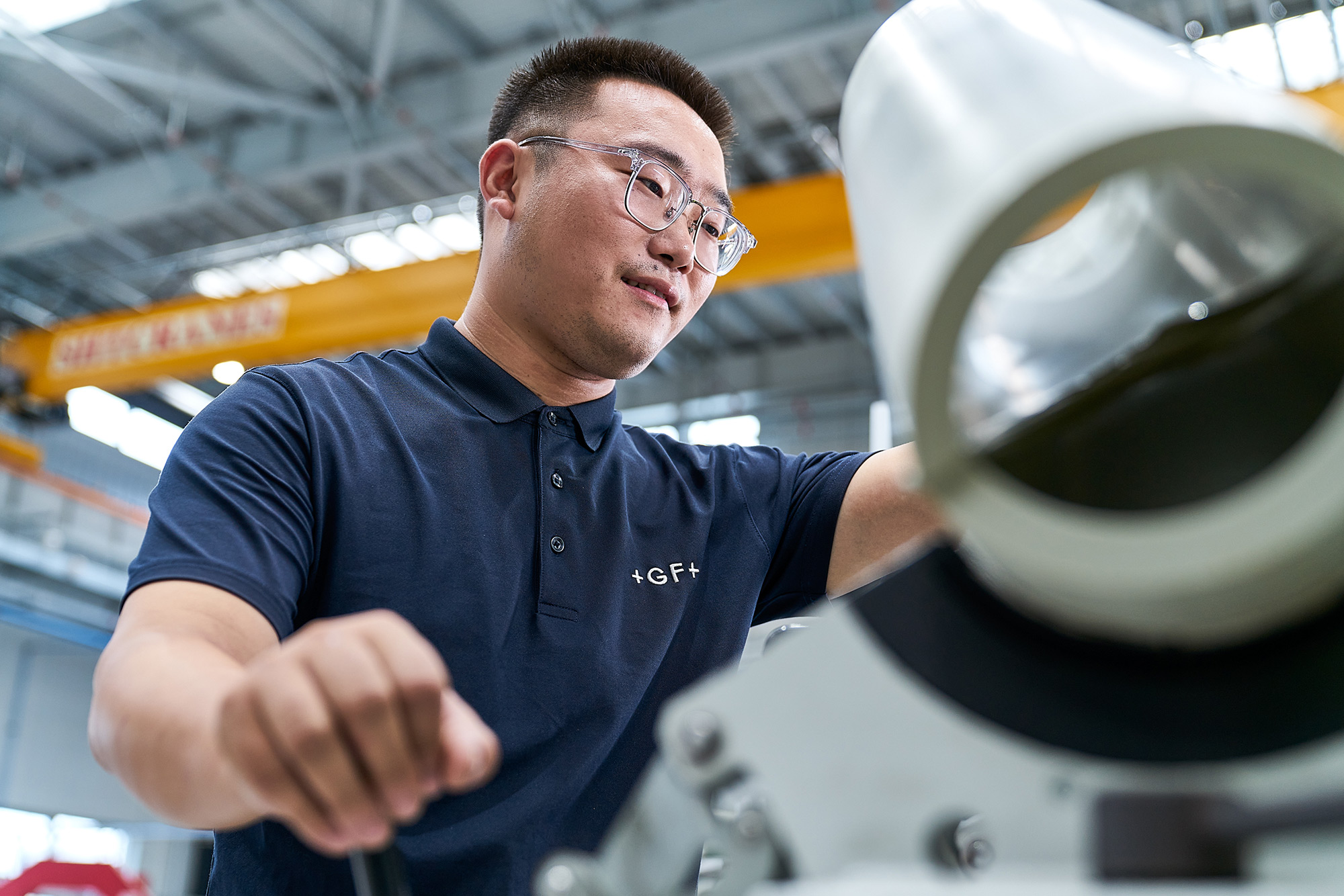 PhilippeRoy_Industrial_1711 Industrial photography capturing a dedicated Georg Fischer employee engaged in tasks on the factory floor, ensuring precision and productivity.