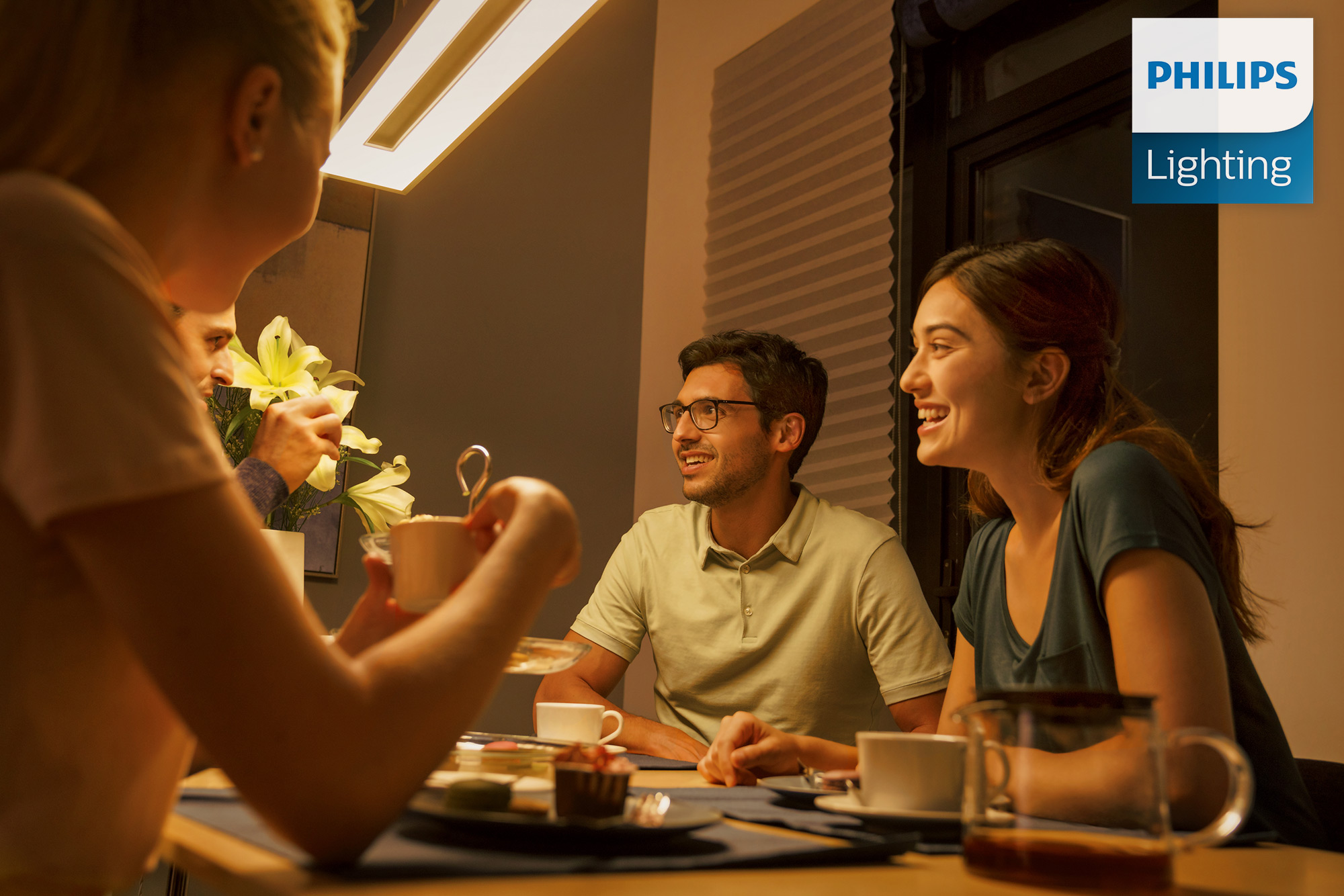 PhilippeRoy_Lifestyle_0199 Models gathered around a dining table for Philips Lighting commercial lifestyle photography shoot.