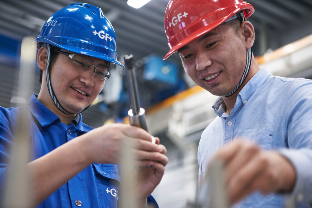 Two engineers discussing tools, featured in industrial photography for Georg Fischer.