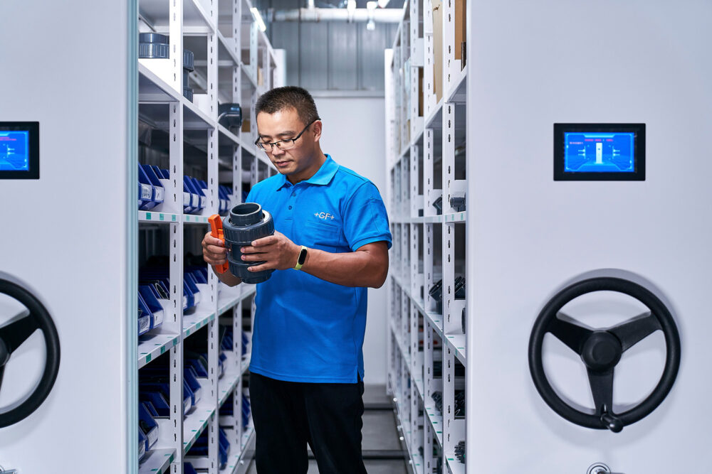 Lab technician selecting a product, featured in industrial photography for Georg Fischer.