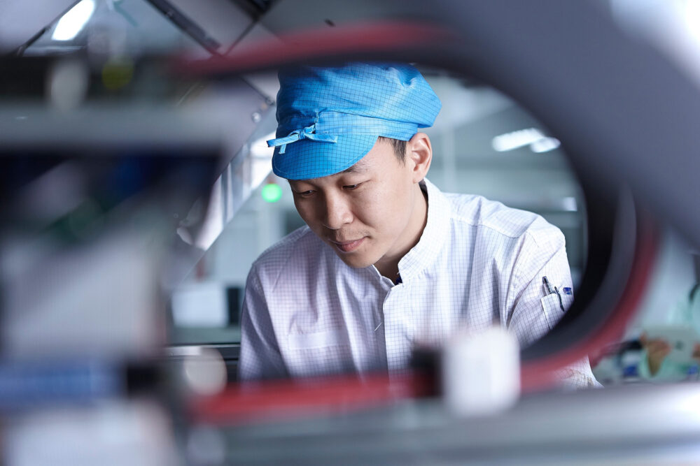 Worker on a clean room factory floor, featured in a science and technology image for Flextronics.