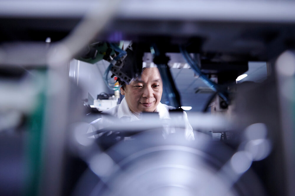 Male engineer inspecting machinery at Flextronics, captured for a high-tech science photography campaign.