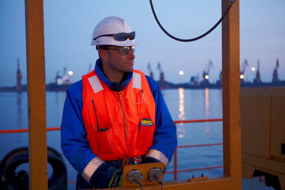 Naval engineer working on a dock, photographed for Dockwise's naval industrial photography.