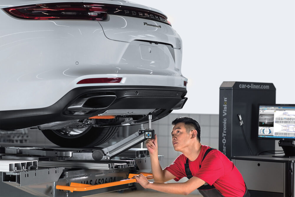 Porsche professional service technician performing maintenance on a Panamera at the Porsche Shanghai Service Center.