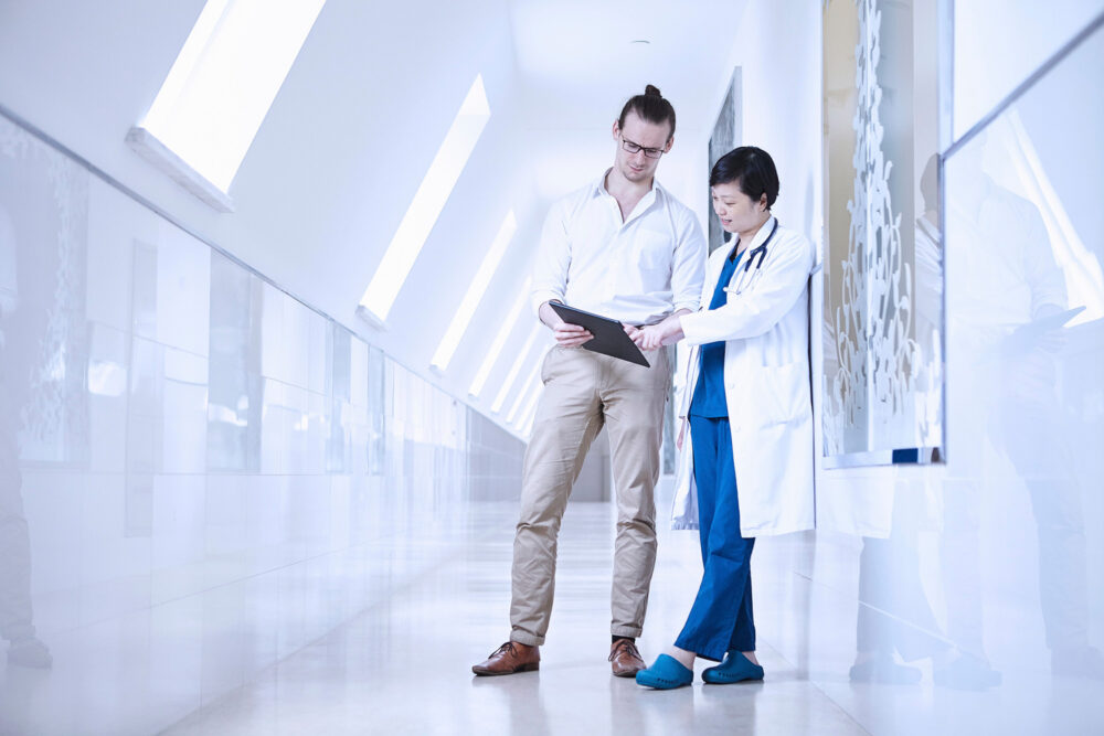 Doctors conversing in a hospital hallway at Ferguson Women's Health, captured for a medical science photography campaign.