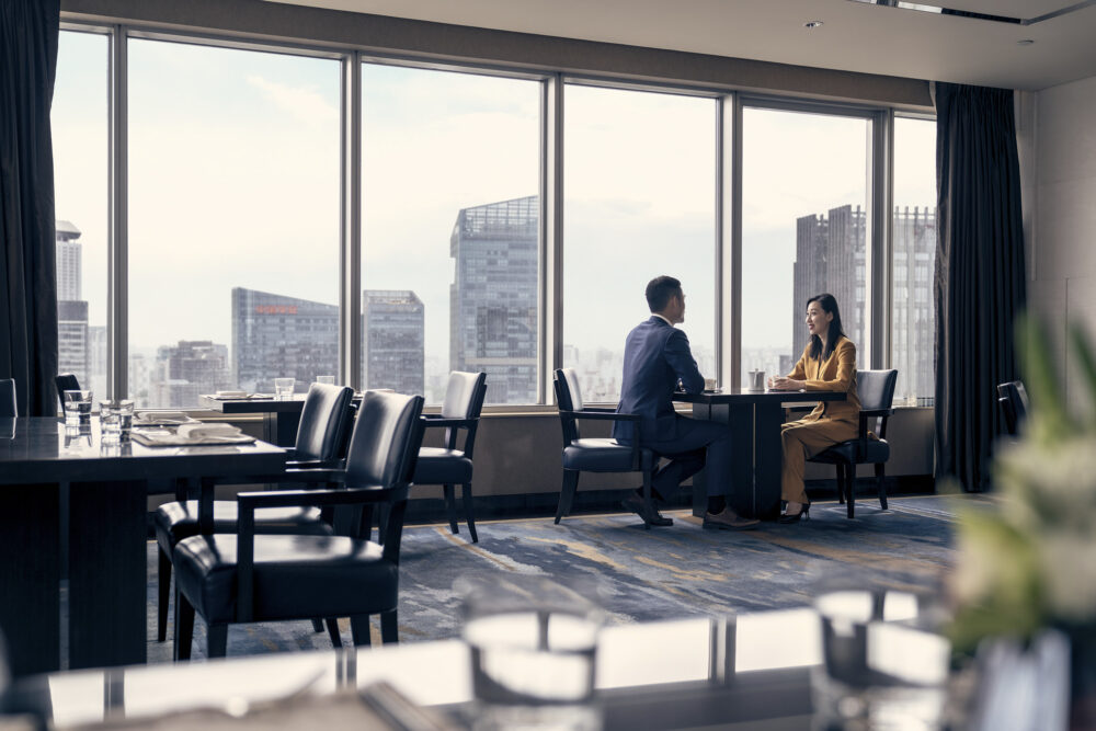 Business meeting in the top floor hotel business lounge in a corporate photography image produced for Four Seasons Hotel Beijing.