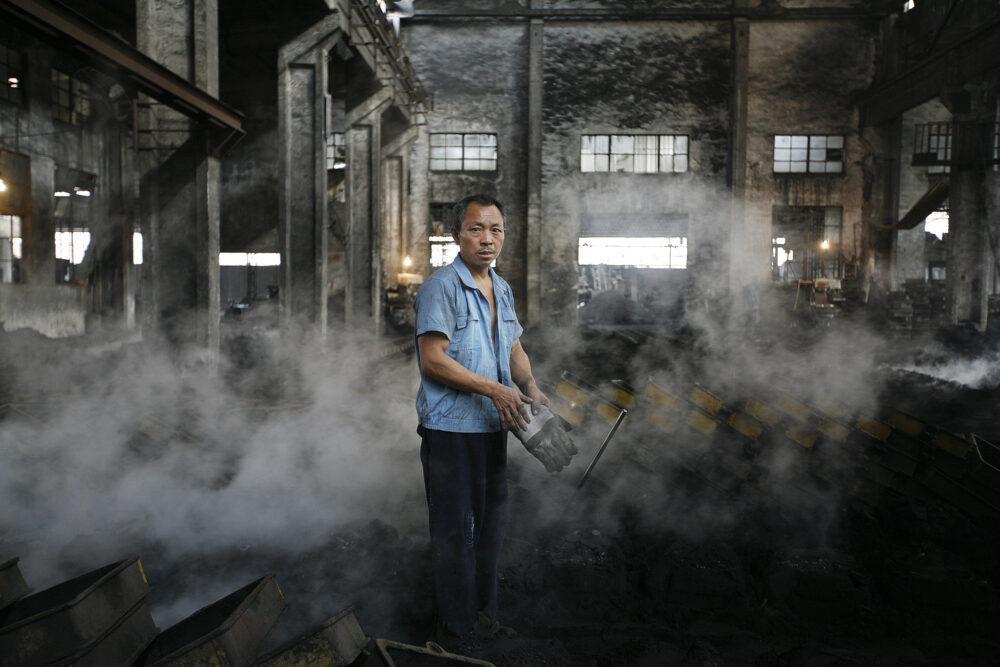 Worker after pouring molten metal into molds, featured in industrial photography for BMF.