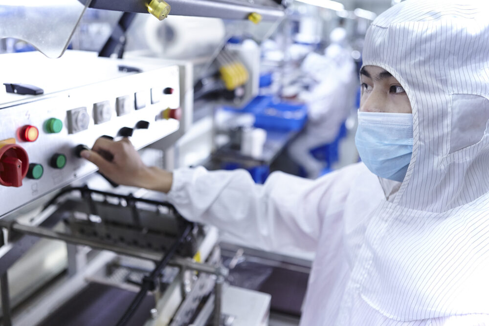 Worker operating a machine, depicted in a science and technology image produced for an eCigarette factory.