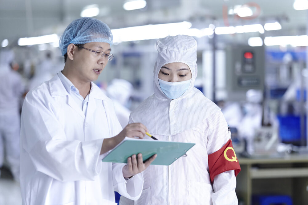 Manager and employee in discussion, captured in a science and technology image produced for an eCigarette factory.