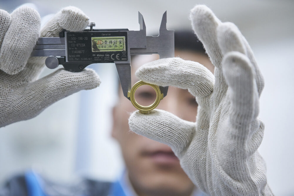 Quality check lab technician measuring a ring, featured in industrial photography for Georg Fischer.