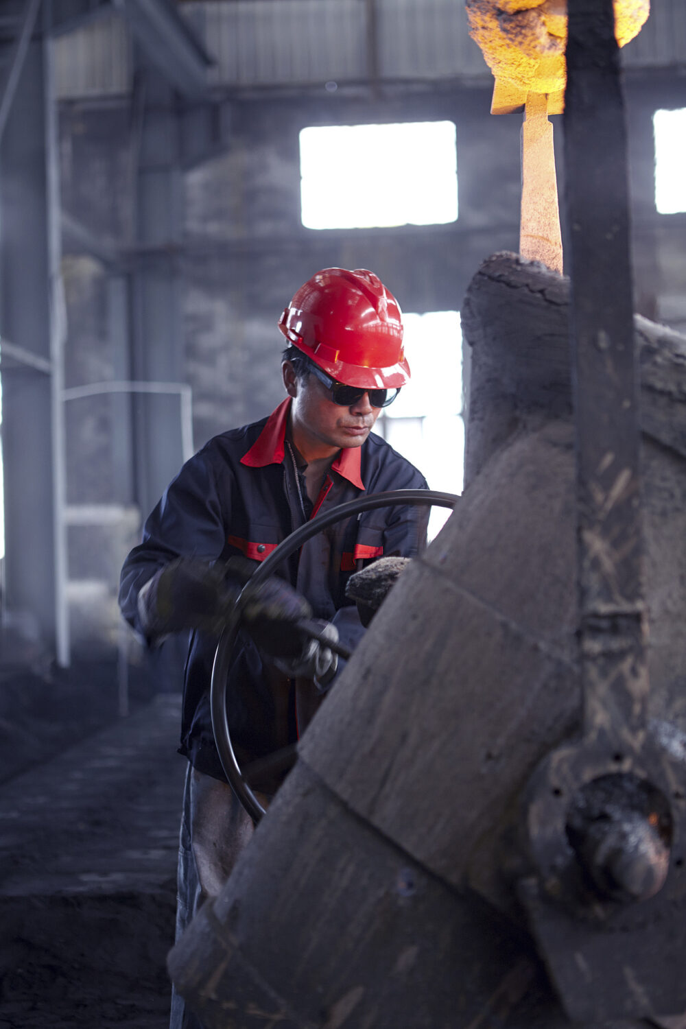 Worker pouring molten metal, featured in industrial photography for BMF.