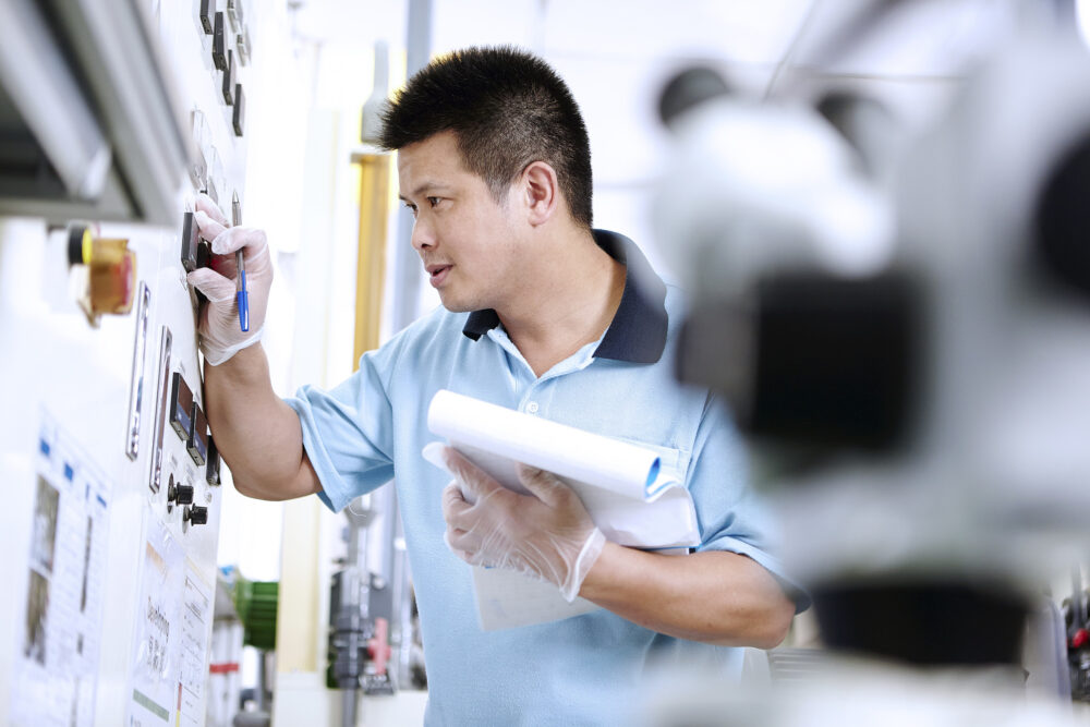 Engineer inspecting machinery, featured in industrial photography for Dennison Avery.