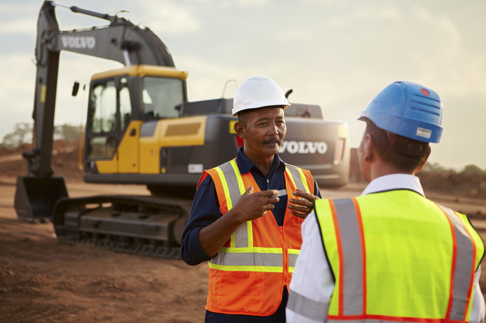 Two machine operators having a discussion on a worksite in Indonesia, part of Volvo CE's construction equipment photography.