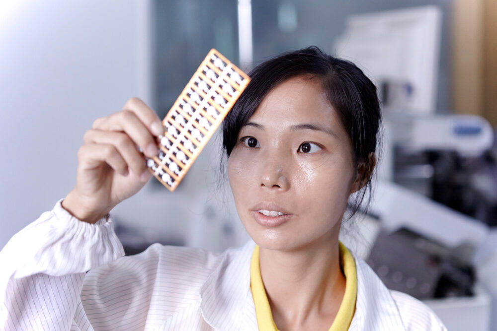 Young female engineer examining an LED board at an LED lighting factory for a science and technology photography campaign.